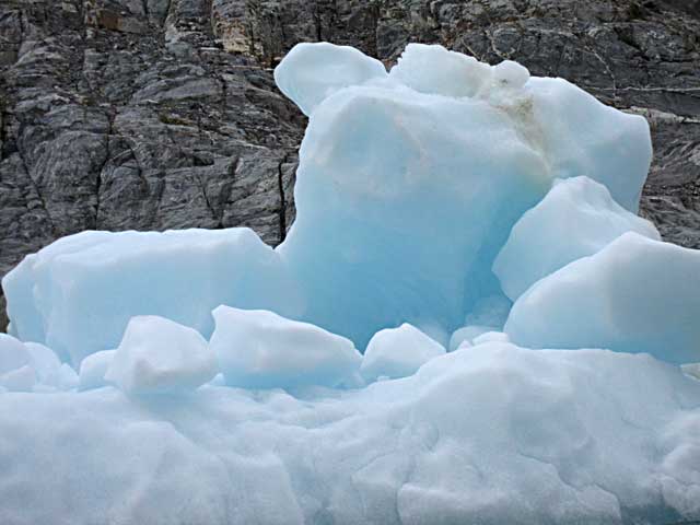 Glacial iceberg with rock wall