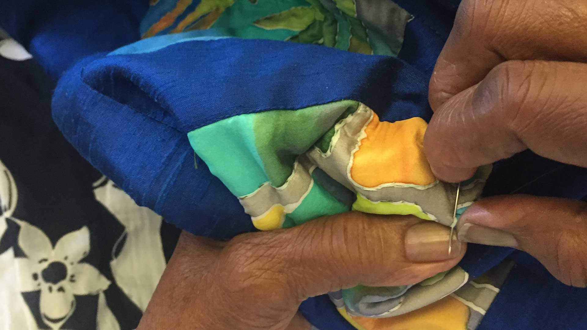 Close-up on senior's hands quilting