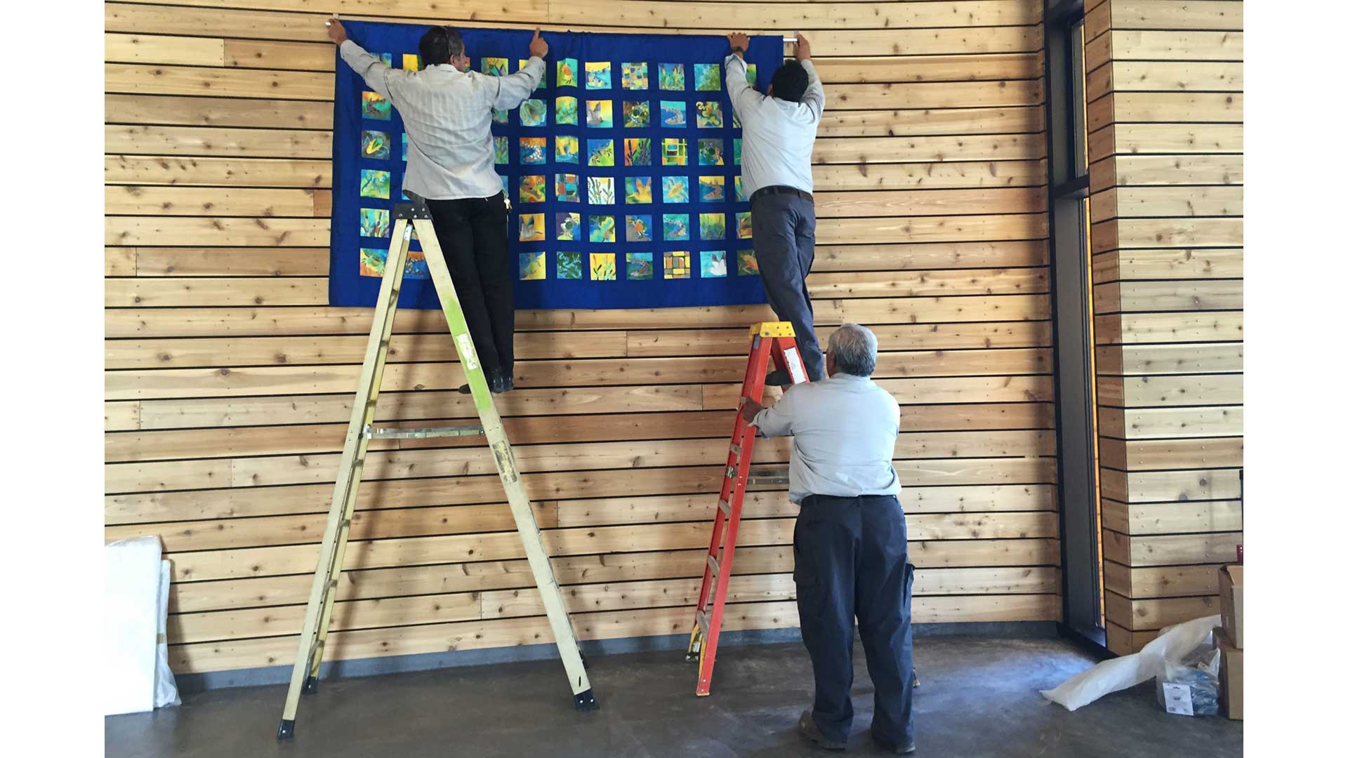 Installing the final quilt at the Cooley Landing Education Center